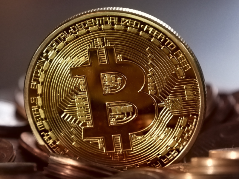 Close-up of a shiny gold Bitcoin coin symbolizing cryptocurrency.