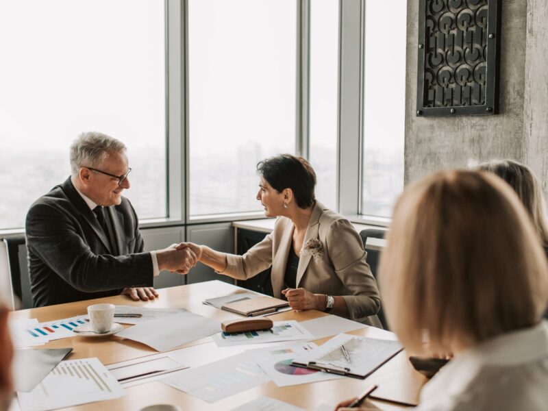 Two professionals shaking hands in a business meeting.